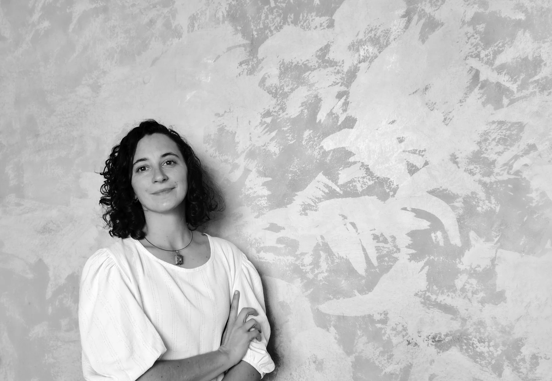 Retrato en blanco y negro de Antonella Accietto frente a una pared texturada.